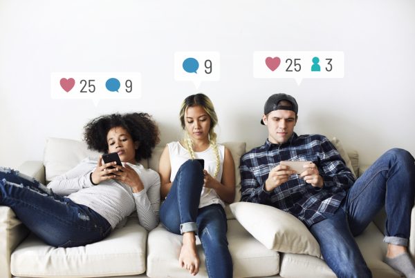 young adults on the couch using social media on their smartphones