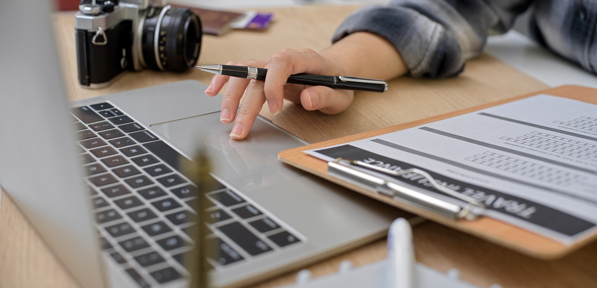 female preparing to travel, searching information for travel insurance on laptop