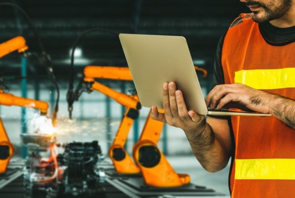 engineer use advanced robotic software to control industry robot arm in factory