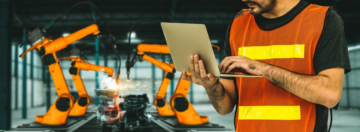 engineer use advanced robotic software to control industry robot arm in factory