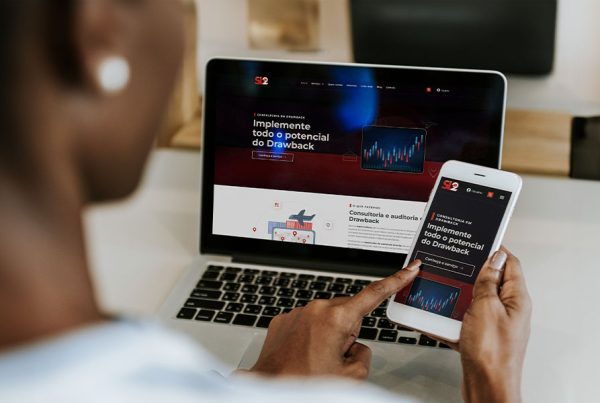 Homem usando laptop e smartphone em escritório moderno