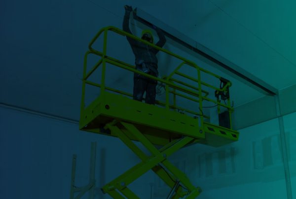Trabalhador em plataforma elevatória em construção