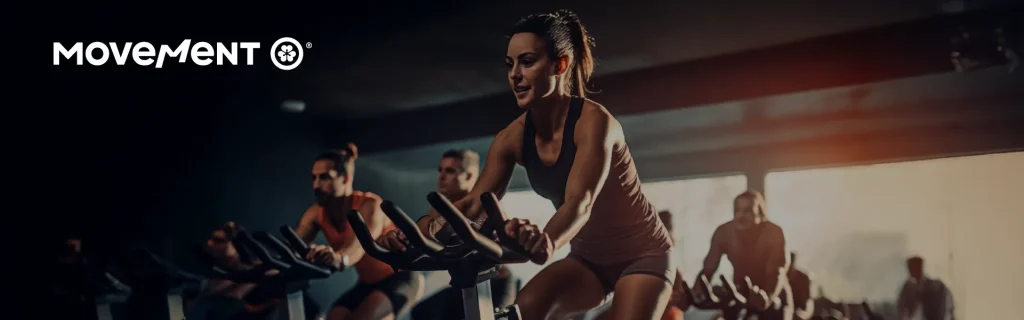 Pessoas praticando spinning em academia iluminada