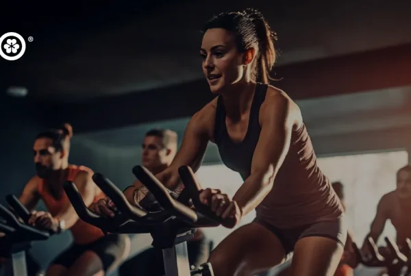 Pessoas praticando spinning em academia iluminada