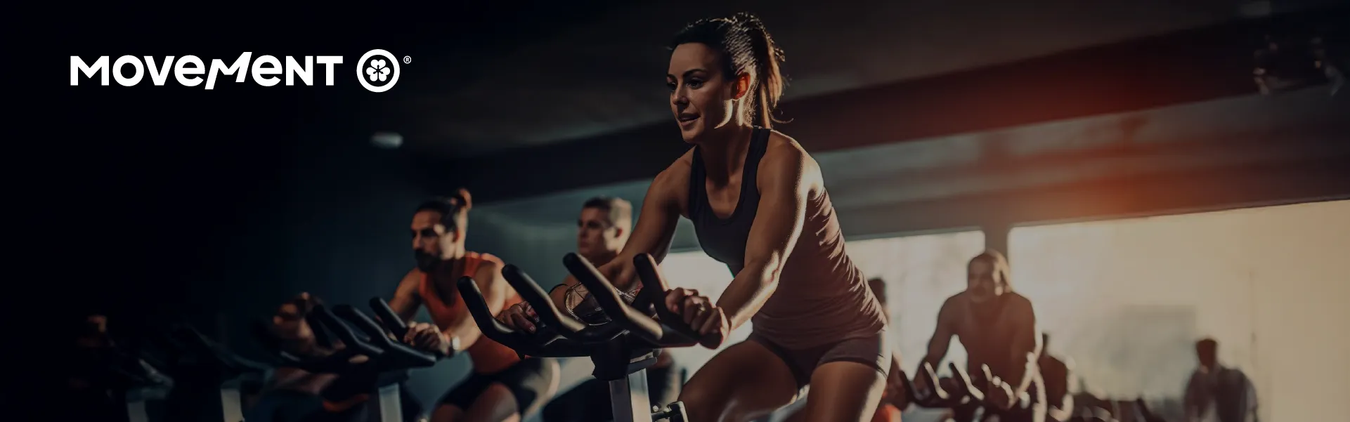 Pessoas praticando spinning em academia iluminada